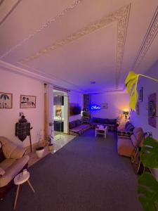 蓋尼特拉的住宿－chambre privée，天花板上设有紫色灯的客厅