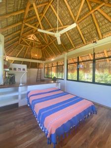 a large bed in a room with windows at Casa shanti penthouse with AC in Puerto Escondido