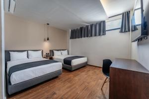 a hotel room with two beds and a desk at Hotel Mexico, Merida in Mérida +27 photos