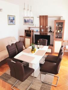 een woonkamer met een witte tafel en stoelen bij Apartments Sunset - 80 m from sea in Stanići