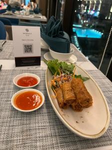 Ấp Long SơnApec Mandala Cham Bay Mũi Né S2411的桌上的一盘食物配上蘸酱