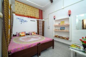 a bedroom with a bed with a pink bedspread at Khajuraho Homestay in Khajurāho