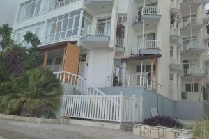 an apartment building with white balconies and a white fence at New Year in the Mediterranean, 10 meters from the sea in Silifke