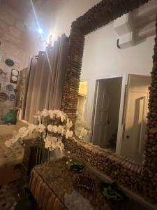um espelho num quarto com um vaso de flores em Aleen Guest House na Nazaré