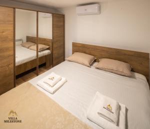 a bedroom with a bed with two towels on it at Villa Milestone Majevica 