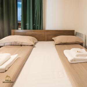 two beds in a bedroom with towels on them at Villa Milestone Majevica 