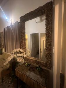 um espelho numa parede num quarto com flores em Aleen Guest House na Nazaré