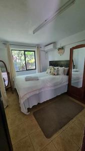 ein Schlafzimmer mit einem großen Bett und einem großen Fenster in der Unterkunft Marys Cottage 