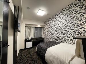 a bedroom with a bed with a black and white patterned wall at APA Hotel Kitakami Ekinishi in Kitakami
