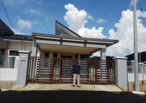 un hombre parado frente a un edificio en Homestay Gua Musang, en Gua Musang