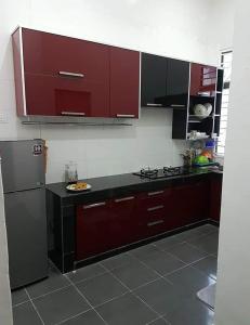a kitchen with red cabinets and a refrigerator at Homestay Gua Musang in Gua Musang