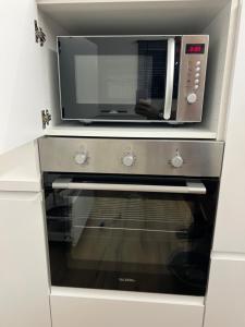 a microwave sitting on top of a kitchen oven at Charmant appartement au look design in Mons