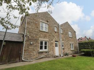 an exterior view of a brick house with a garage at Prudhoe Cottage in Prudhoe