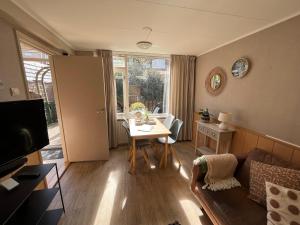 uma sala de estar com um sofá e uma mesa em Vakantiewoning aan de Kust 21 em Egmond aan Zee