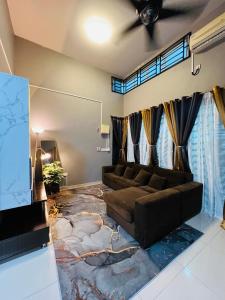 un soggiorno con divano e un grande tappeto di Khalish homestay a Keluang