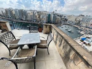 - Balcón con mesa y sillas y vistas a la ciudad en 4 bedroom seafront apt St Julian’s, en San Julián