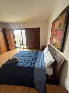 1 dormitorio con 1 cama grande con manta azul en 4 bedroom seafront apt St Julian’s, en San Julián