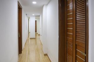 a hallway with white walls and wooden doors at 79600 The Premium Villa in New Delhi