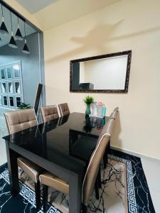 mesa de comedor negra con sillas y espejo en Khalish homestay, en Keluang
