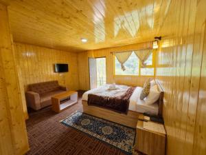 a bedroom with a bed and a chair and a window at Apple Valley Cottages Lachung in Lachung