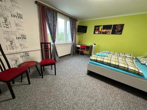 sypialnia z łóżkiem, krzesłami i biurkiem w obiekcie Apartmány MK w mieście Nové Hrady
