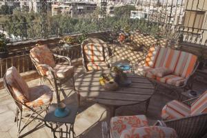 um pátio com cadeiras e uma mesa na varanda em Luxurious Penthouse in Degla Maadi no Cairo