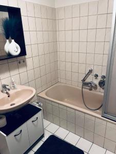 a bathroom with a bath tub and a sink at Ferienwohnung Stadtgracht in Nordhorn