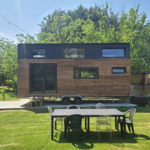 ein Haus mit einem Tisch und Stühlen davor in der Unterkunft Mini maison Tiny house 6 per 3800m2 jardin Jacuzzi in Pontault-Combault