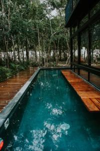 einem Pool mit Holzterrasse und einem Haus in der Unterkunft K NAJ Community Cenote Residence in Balcheil