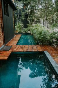 einen kleinen Pool mit einer Holzterrasse und einem Pool in der Unterkunft K NAJ Community Cenote Residence in Balcheil