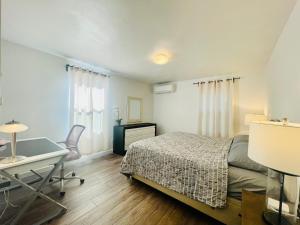 een slaapkamer met een bed, een bureau en een tafel bij Super Privacy Lakeshore Forest Home with Air Conditioners at Haller Lake in Seattle