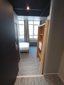 Cet appartement comprend une chambre avec un lit et une fenêtre. dans l'établissement Le 12 studio neuf wifi app 11, à Saint-Étienne