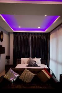 1 dormitorio con 1 cama con luces moradas en el techo en Ratsamee Poolvilla P, en Pattaya South 11 fotos más