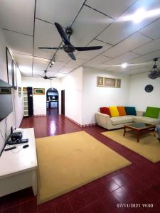 sala de estar con sofá y ventilador de techo en Padang Besar City Homestay, en Padang Besar