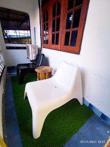 Habitación con silla blanca y mesa. en Padang Besar City Homestay, en Padang Besar