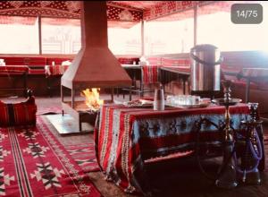 a room with a table and a fireplace in it at Bedouin Memories Camp in Wadi Rum