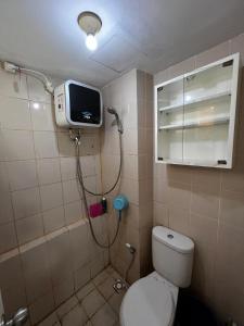 a bathroom with a toilet and a tv on the wall at Apartemen kalibata city By Alia Property in Jakarta