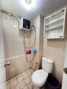 a bathroom with a shower with a toilet and a tv at Apartemen kalibata city By Alia Property in Jakarta