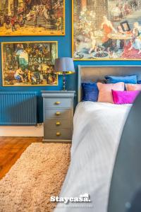 Stunning 3 Bdr Apartment 5 Min From Haymarket في إدنبرة: غرفة نوم بها سرير ولوحات على الحائط