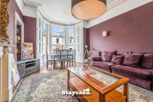 Stunning 3 Bdr Apartment 5 Min From Haymarket في إدنبرة: غرفة معيشة مع أريكة وطاولة