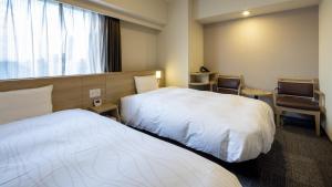 Ένα ή περισσότερα κρεβάτια σε δωμάτιο στο Dormy Inn Hiroshima Annex