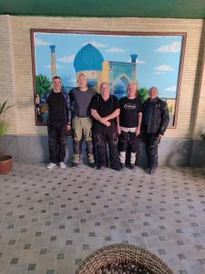 a group of men standing in front of a wall at HOTEL MEHRIBON in Samarkand
