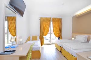 a hotel room with two beds and a desk with a computer at Eco Hotel Cleofe in Caorle
