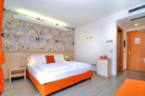 a bedroom with a bed and a wall with birds on it at Eco Hotel Cleofe in Caorle