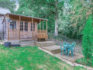 a wooden cabin with a table and a bench in a yard at Oak Villa in Cinderford