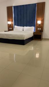 1 dormitorio con 1 cama con 2 mesitas de noche y 2 lámparas en ريف الشاطئ للشقق الفندقية en Dammam