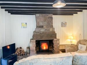a living room with a stone fireplace and a couch at Meadow View Cottage in Highpeak Junction