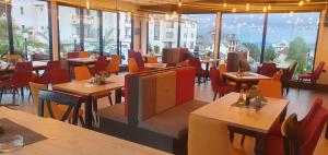 um restaurante com mesas e cadeiras de madeira e janelas em K19 Milmari Resort & Spa em Kopaonik