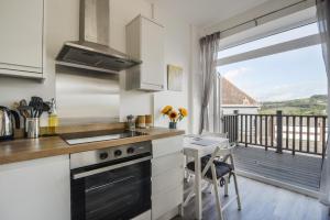 a kitchen with a stove top oven next to a balcony at Lyme Zest in Lyme Regis