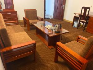 a living room with a coffee table and chairs at Bao Son Hotel in Ninh Lão